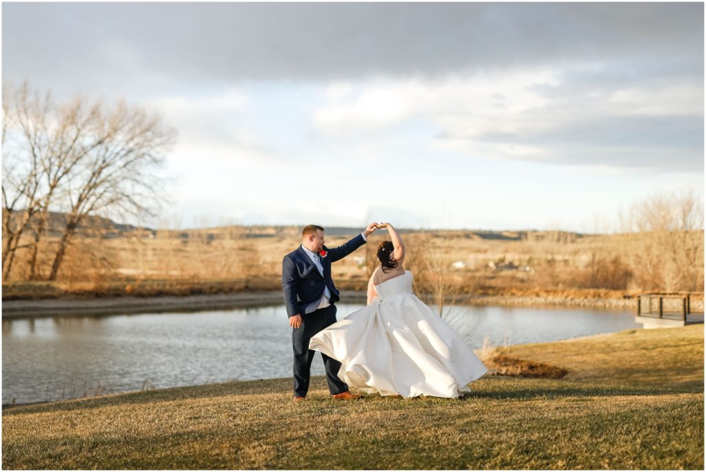 Bride and groom dancing by a pond at Camelot Ranch