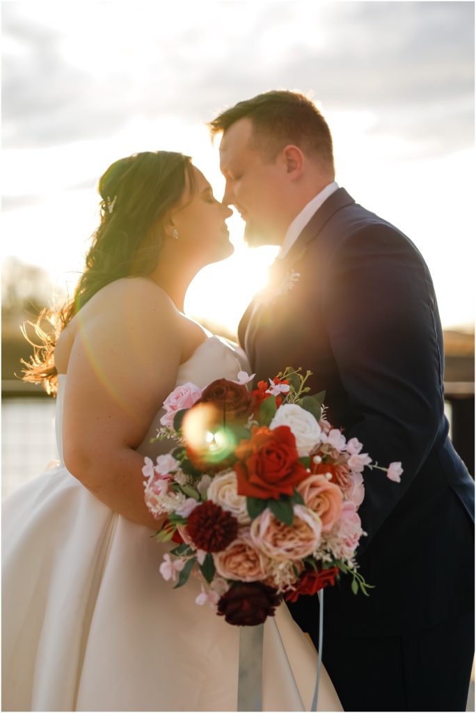 Bride and groom nose to nose with sun glow shining through