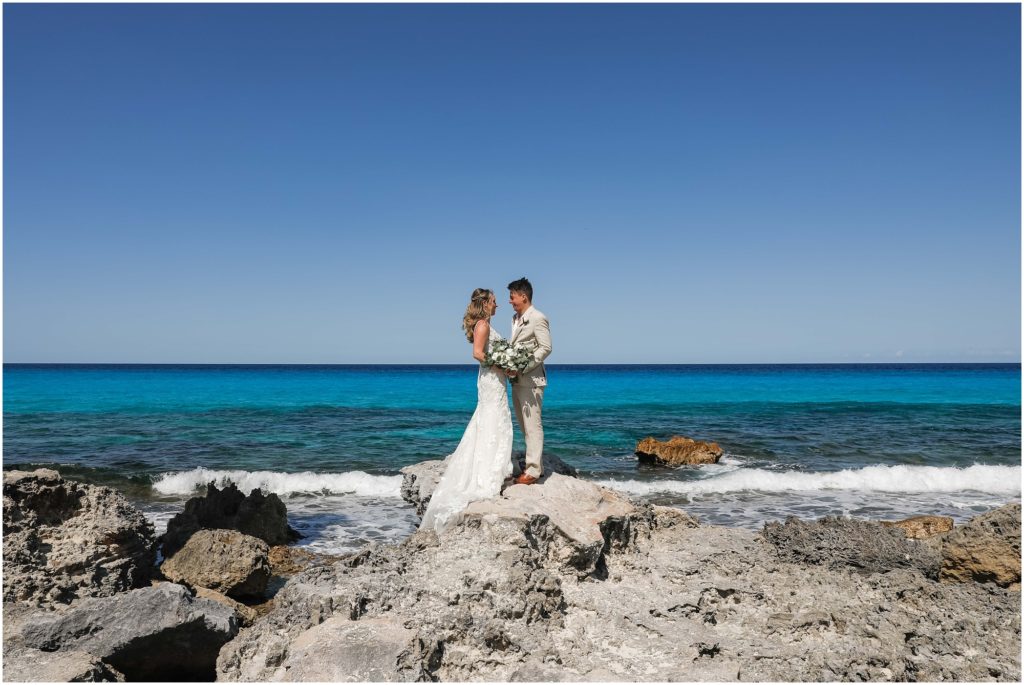 Cancun Destination Wedding Bride and Groom on rocky shoreline with beautiful blue ocean