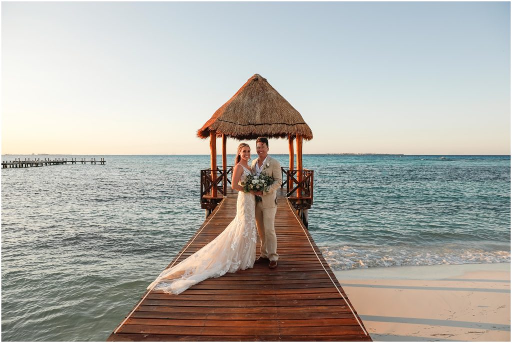 Cancun Destination Wedding bride and groom standing on dock overlooking the ocean