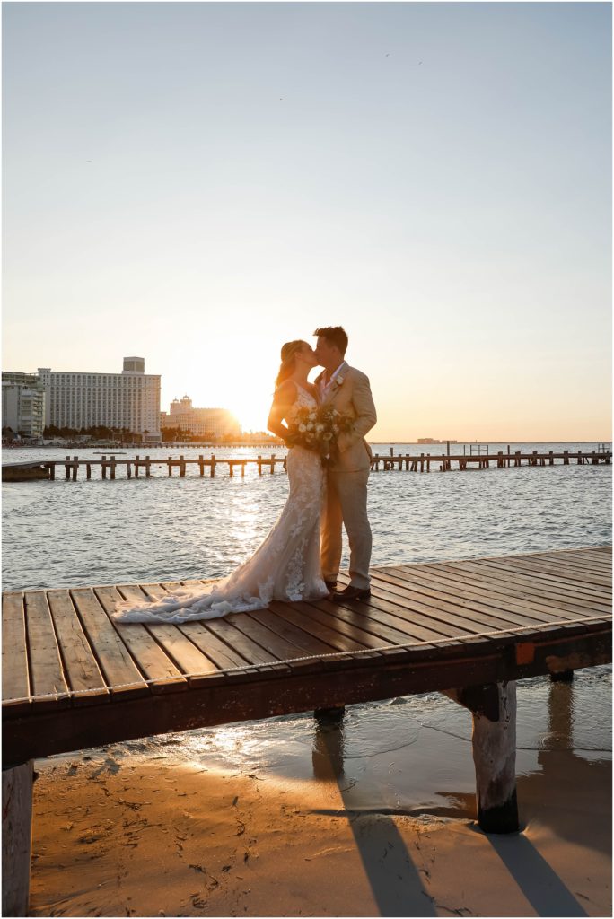 Cancun Destination Wedding at Hyatt Ziva in Mexico Bride and Groom on dock kissing at sunset by ocean