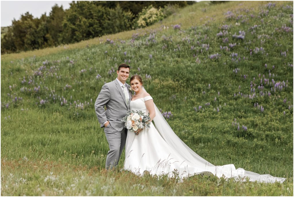 Rainy Spring Wedding Bride and Groom in green field with purple flowers