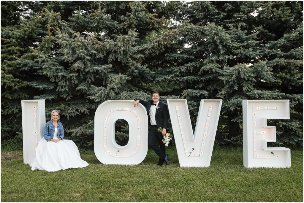 Bride and groom standing in front of LOVE sign at Venue 406 Wedding