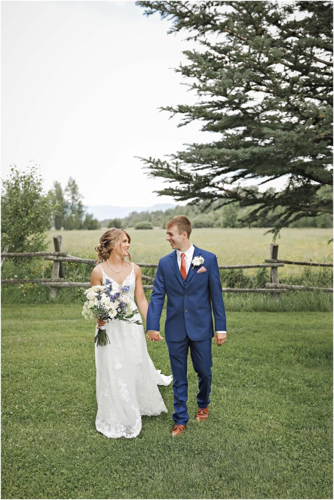 MT Wildflower Wedding Bride and Groom walking in grassy field
