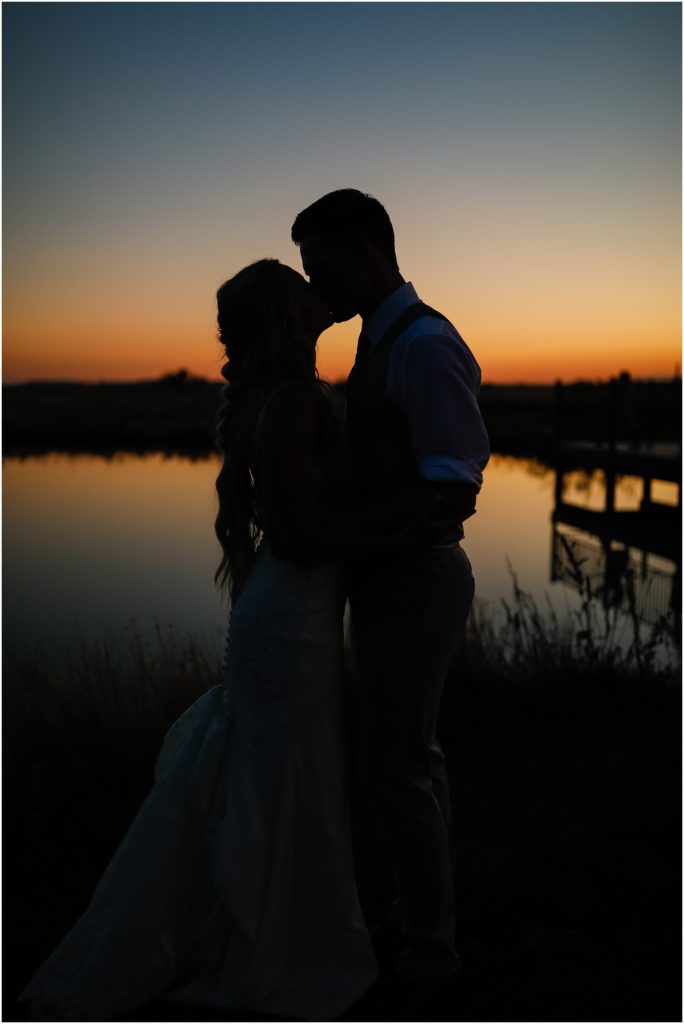 WillowBrooke Barn Wedding Sunset silhouette of Bride and Groom kissing