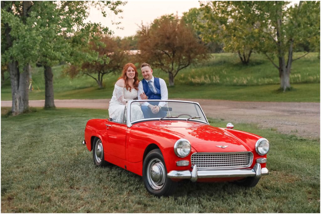 Zoo MT Wedding Sunset Photos with Bride and Groom sitting in vintage red car